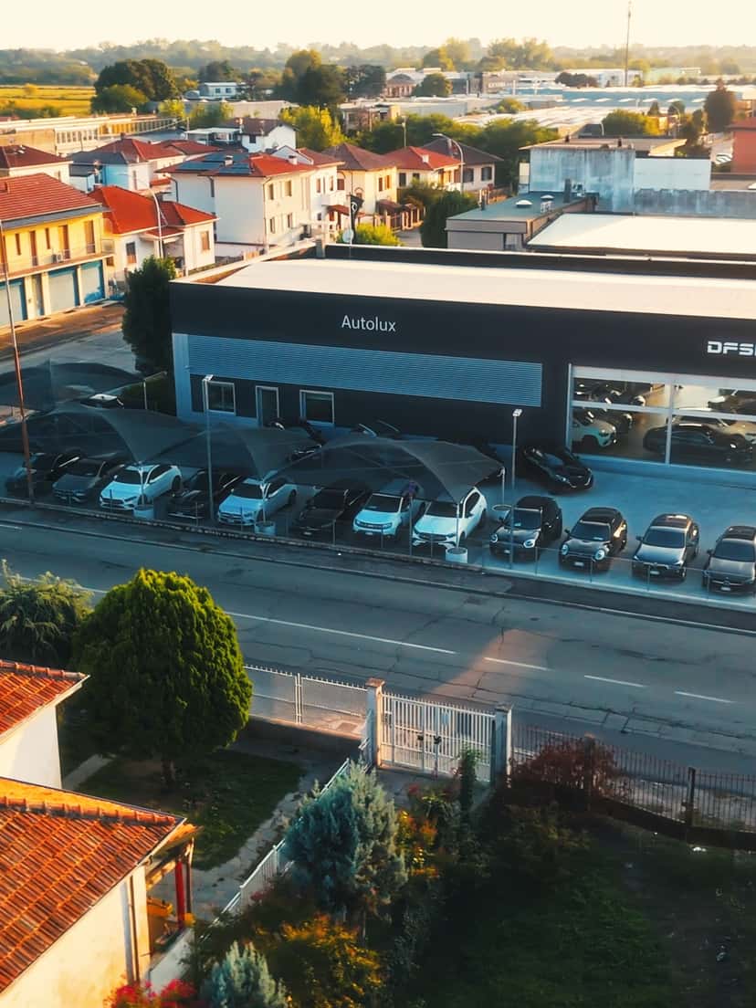 Il salone di Autolux a Vigevano al tramonto, visto dal drone, con le vetture in vendita nel piazzale